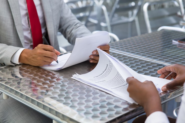 business partners checking and signing document