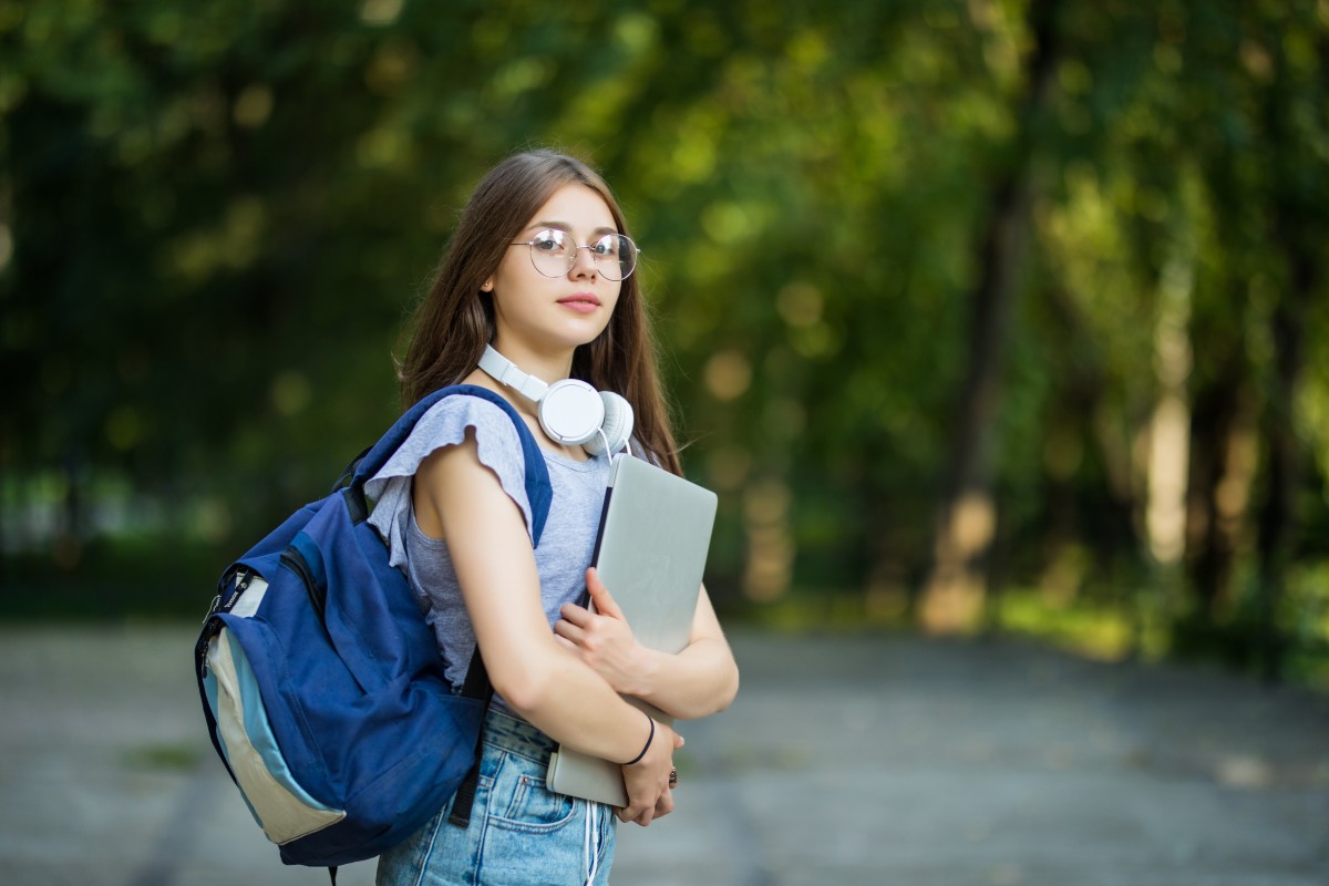 cheerful-attractive-young-woman-with-backpack-notebooks-standing-smiling-park (1) (1).jpg
